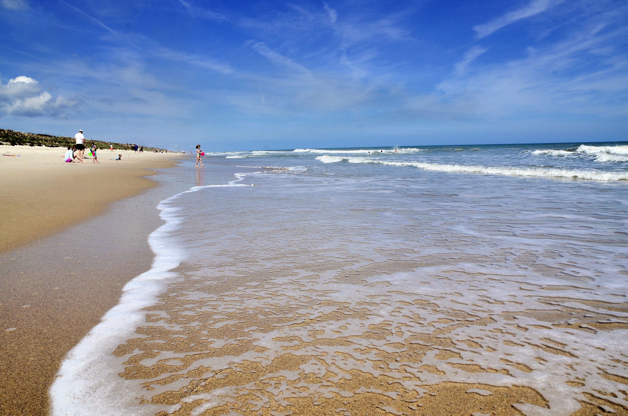 beach with clear skies and a few people by the sand