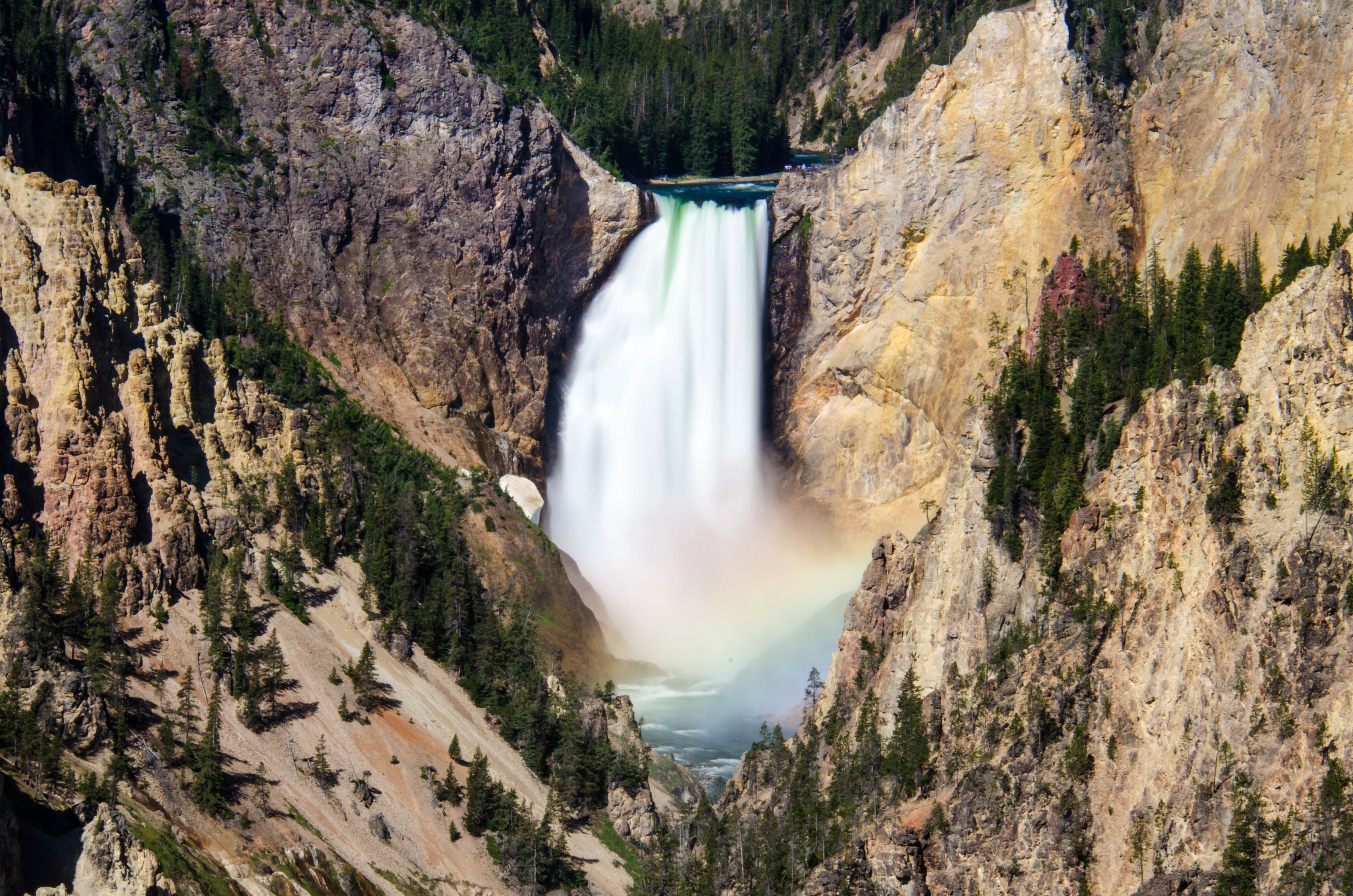 waterfall between rocky mountain and a rainbow 