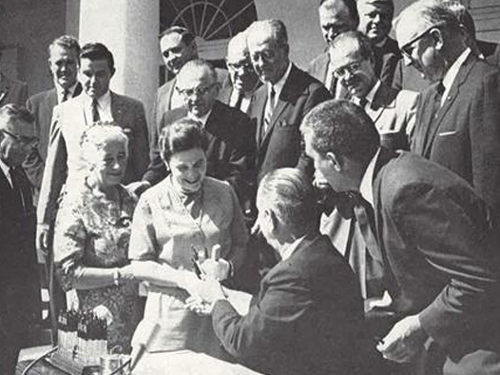 Alice Zahniser receives a pen used to sign the Wilderness Act into law from President Lyndon B. Johnson