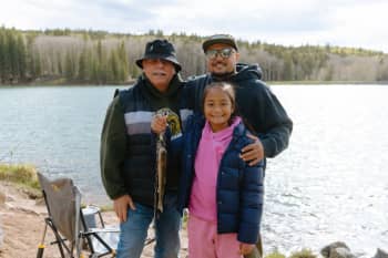 Father, son and granddaughter hold fish caught on public lands. Copyright The Wilderness Society
