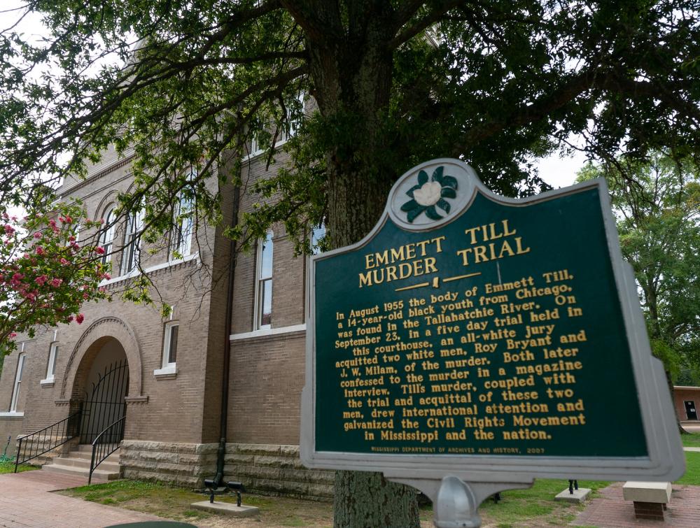 signage of a historical marker that says "emmett till murder trial"