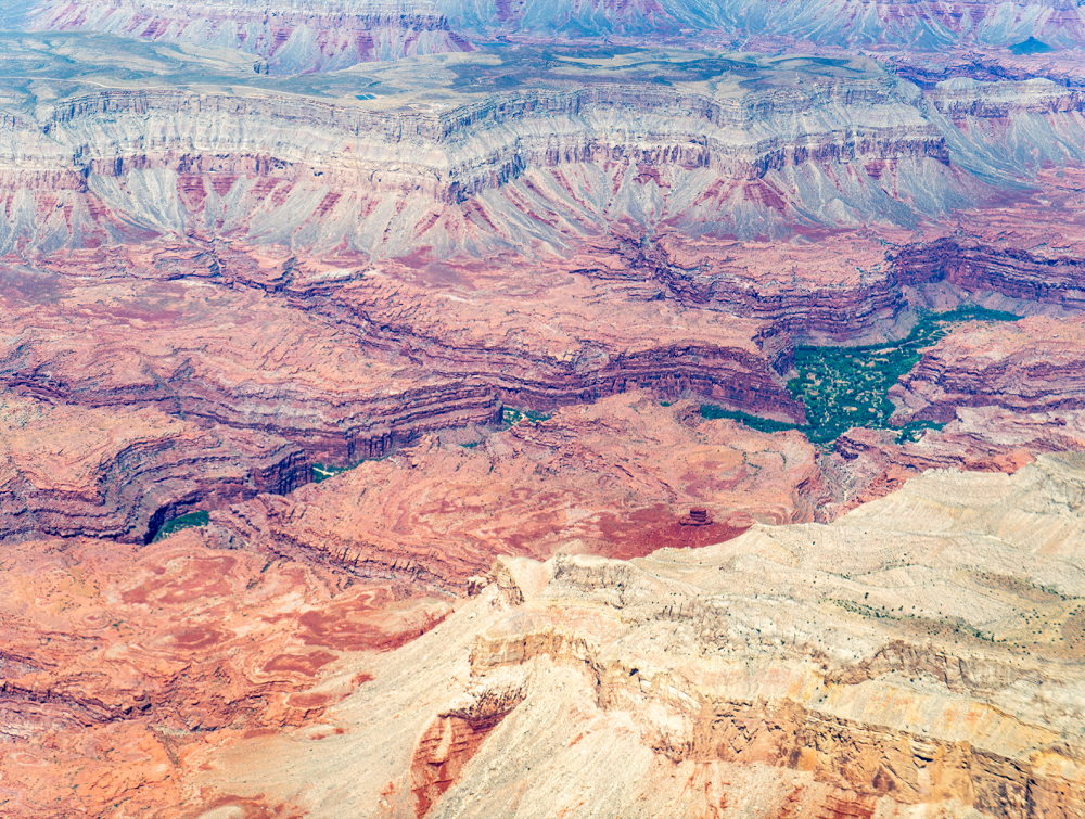 aerial view of red canyons and river flowing in between