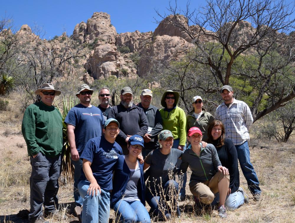 Group of veterans poses in front of mountainous desert landscape, Coronado National Forest, Arizona