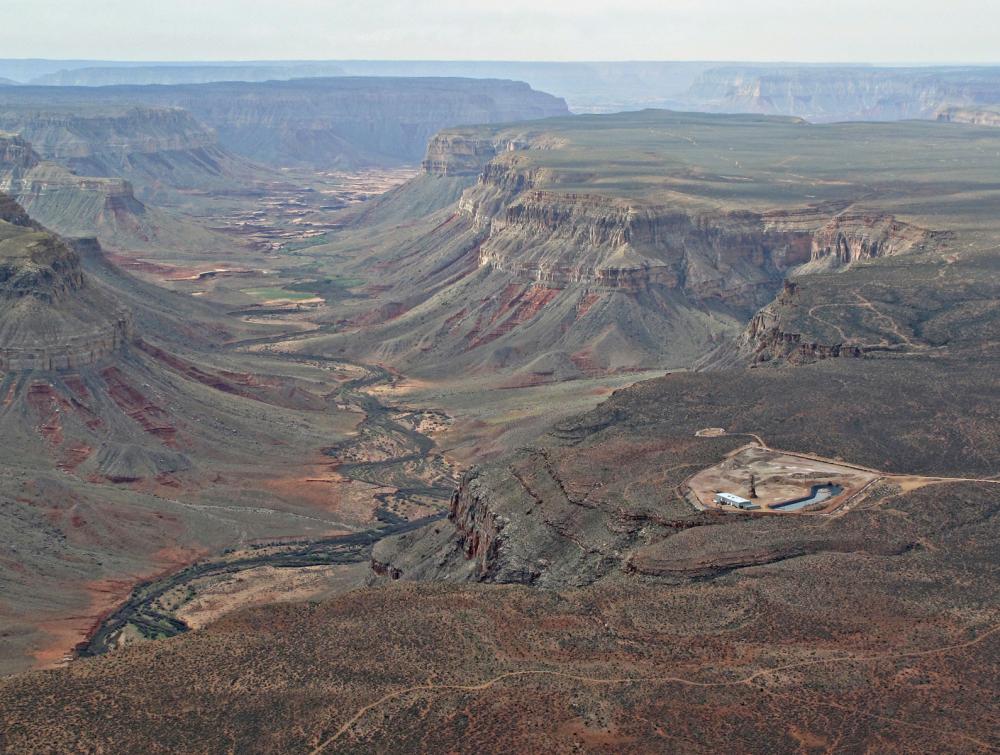 Aerial view of large canyon with small human-made development visible on near rim