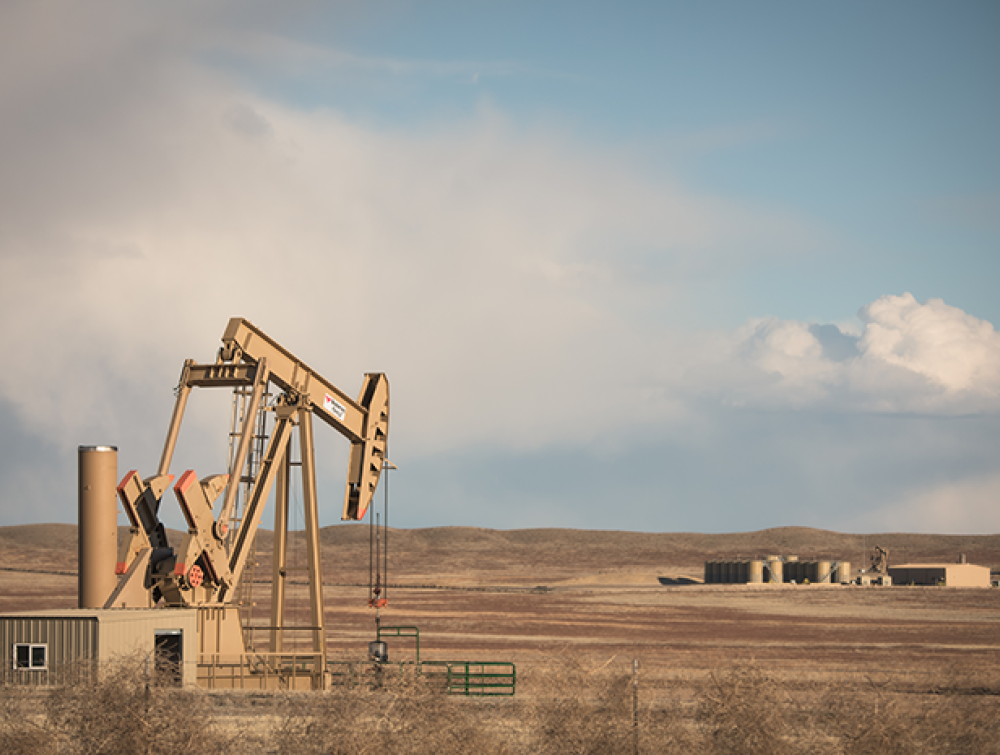 An oil well sits on Colorado grasslands