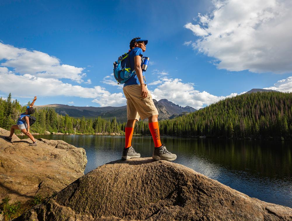 person hiking looking at lake 