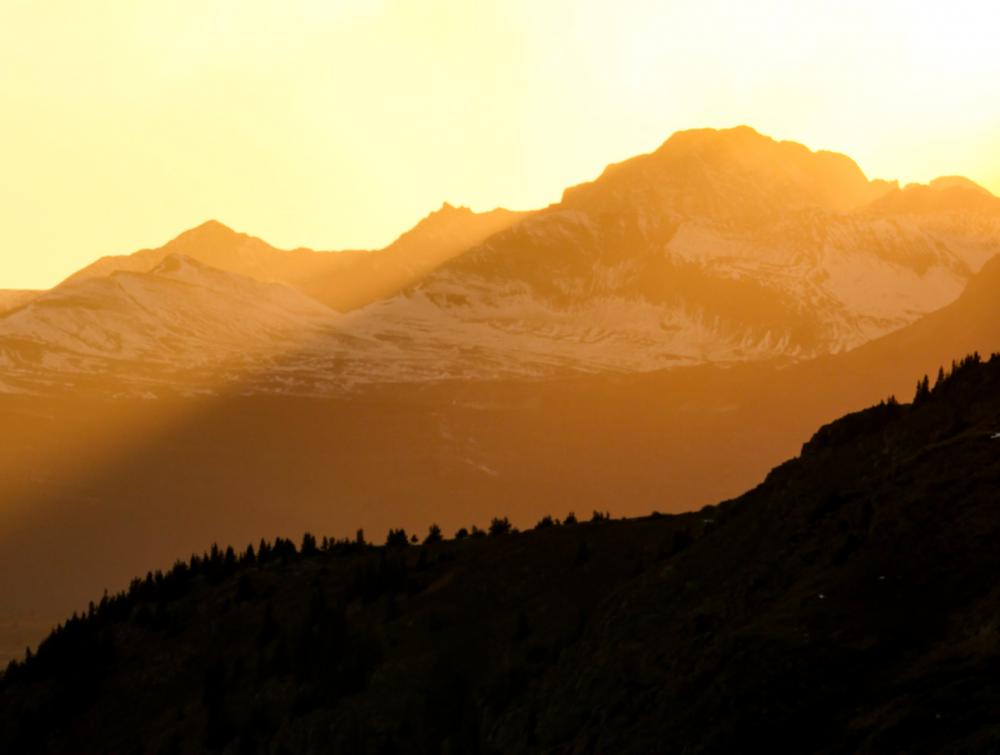 Layers of backlit mountains at sunset.