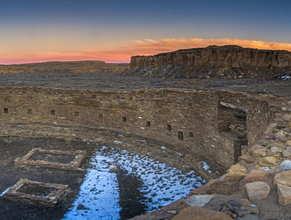 A view of the Chaco Canyon ruins with the sunset on the background.