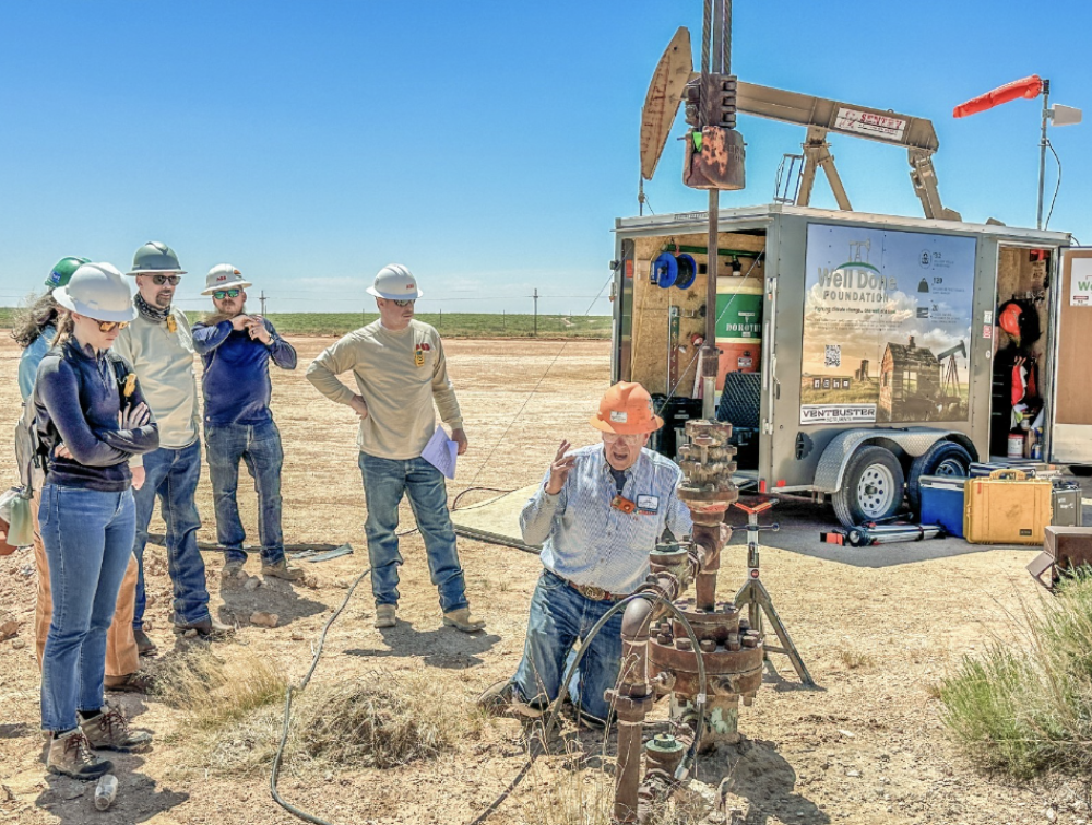 A team of people observe an oil and gas well