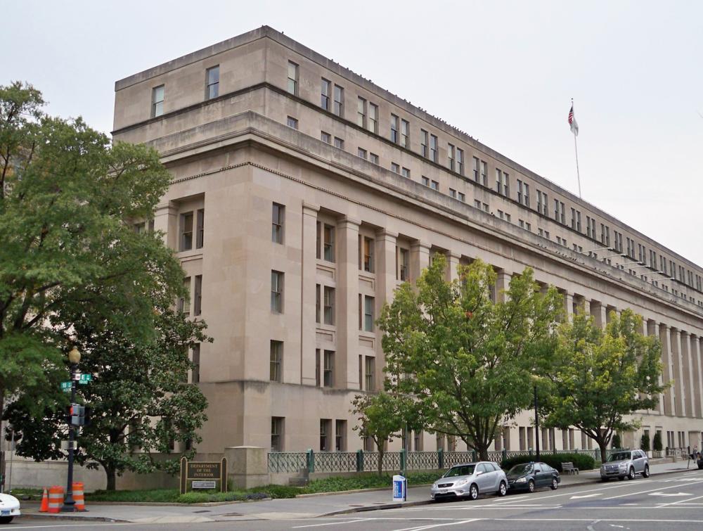Building in downtown setting with cars parked alongside it