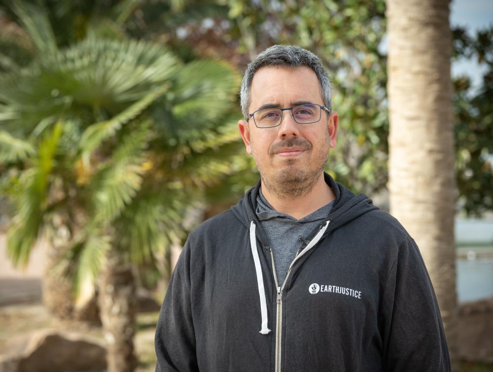 Portrait of man with palm trees in the background