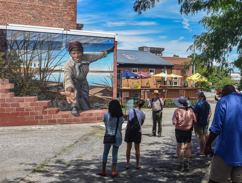 A ranger gives a talk in front of the Harriet Tubman Mural