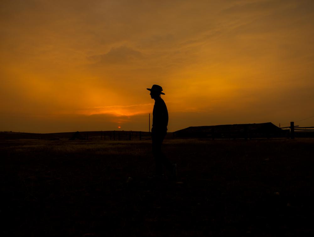 Silhouette of a person in front of a smoky sky. 