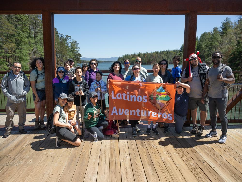 people hanging out holding banner that reads "latino aventureros"