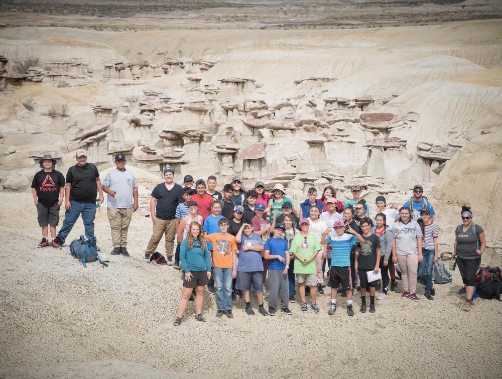 Group of kids posing in front of rock formations in Ah-shi-sle-pah Wilderness, New Mexico