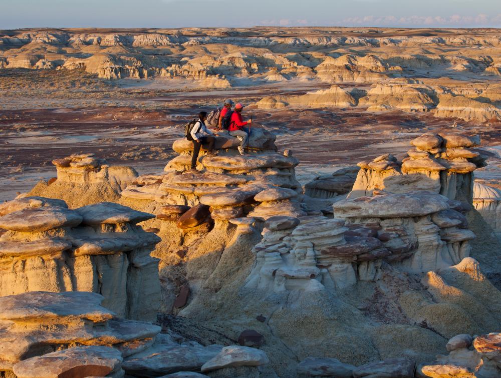 3 People sit atop a rocky landscape at the Ah-shi-sle-pah Wilderness