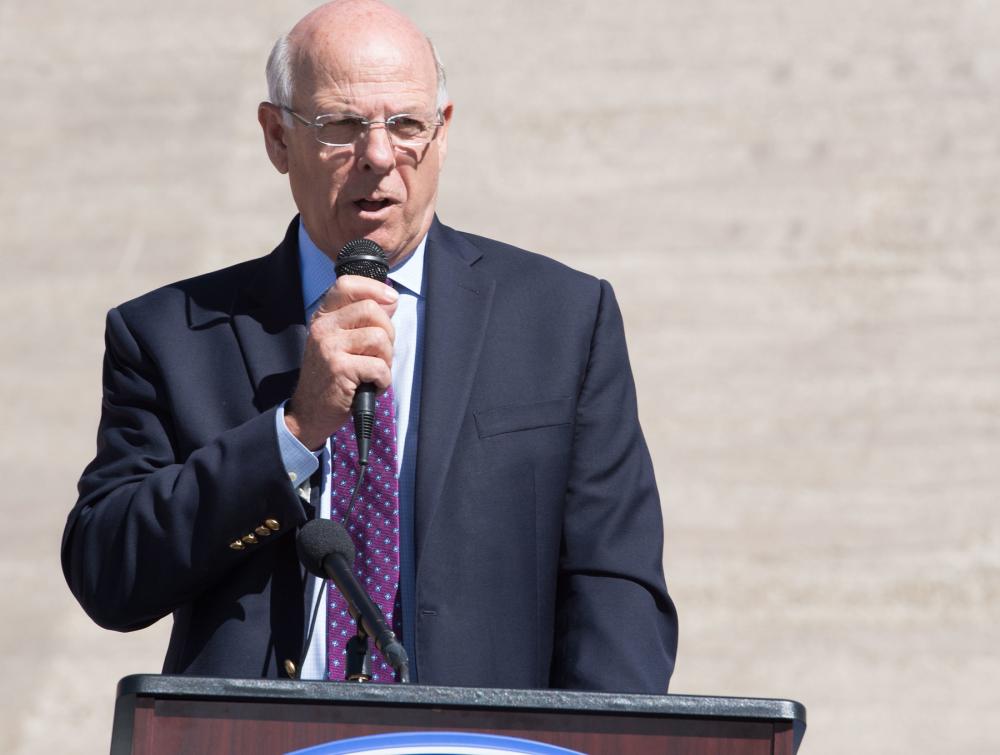 Man standing at lectern with microphone in his hand 