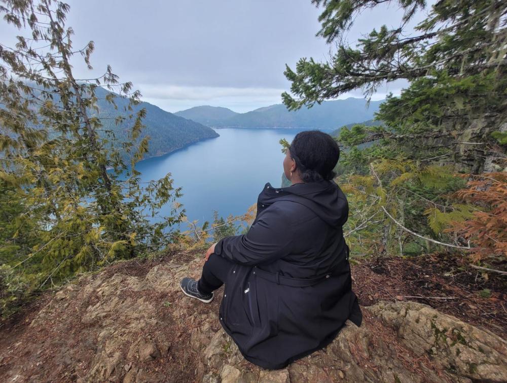 woman looking at a lake from up a mountain