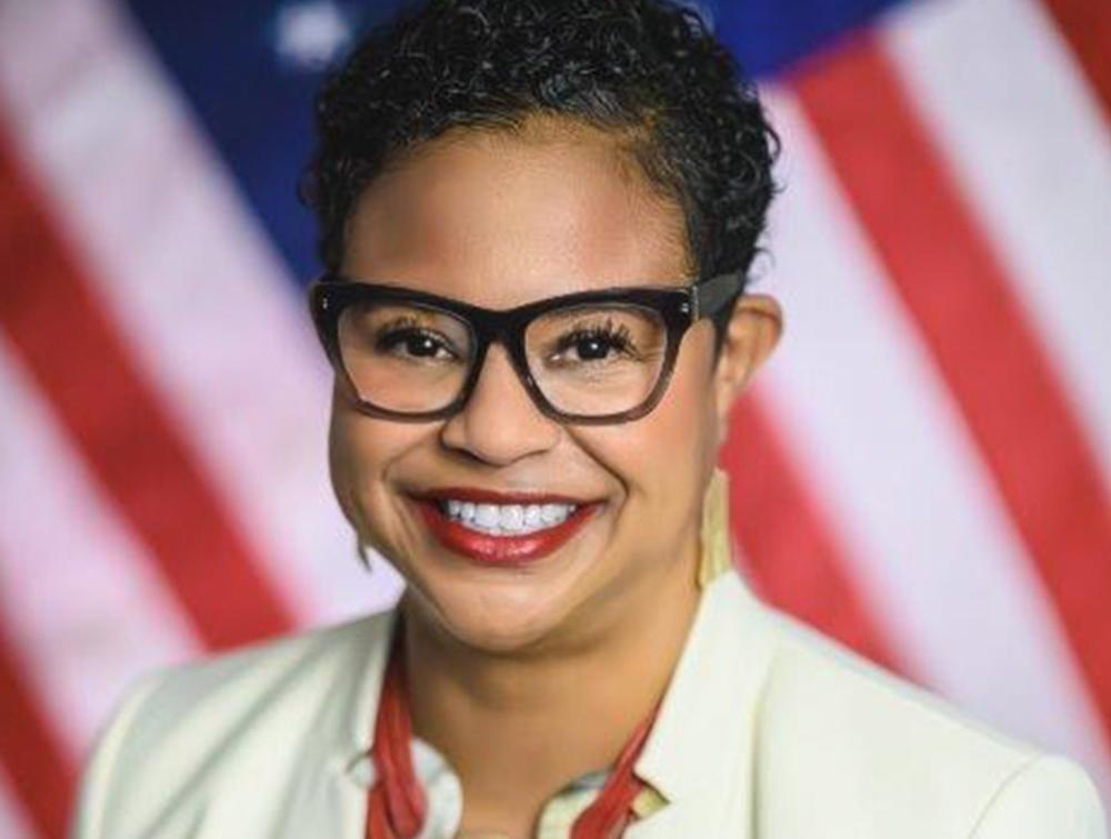 Woman standing in front of American flag-patterned backdrop