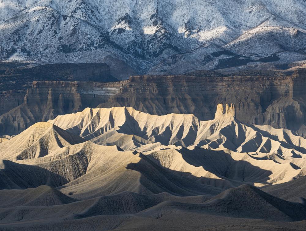 Rocky mountains and buttes swathed in dramatic shadows