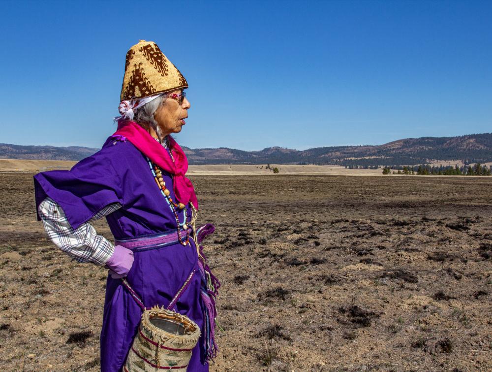 A person wearing a traditional gathering basket.