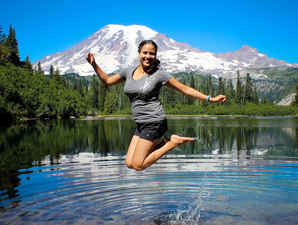 A person jumps with joy in a scenic lake