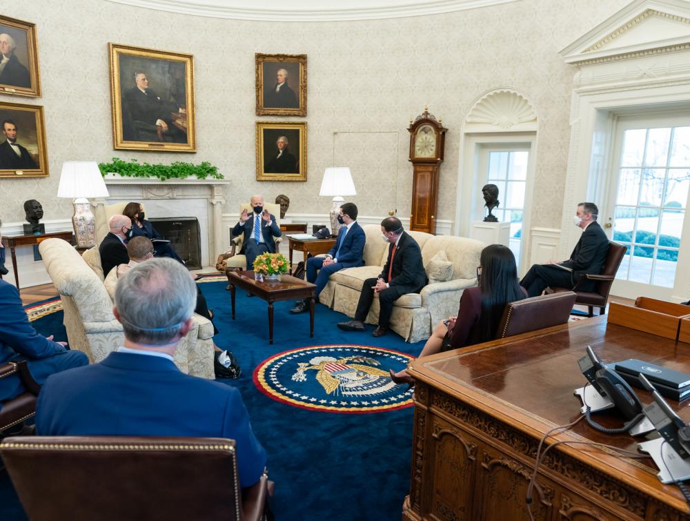 Group of people in formal dress meeting with President Joe Biden in the Oval Office of the White House