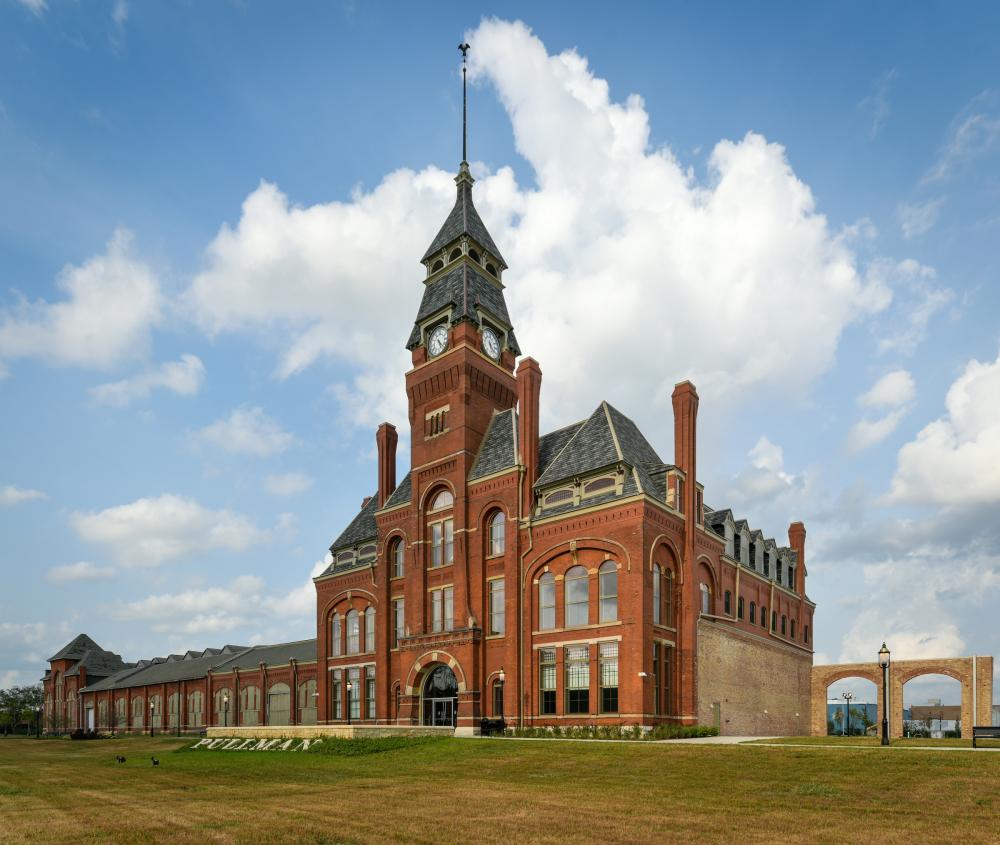 Exterior of tall brick structure with big windows and a clock tower