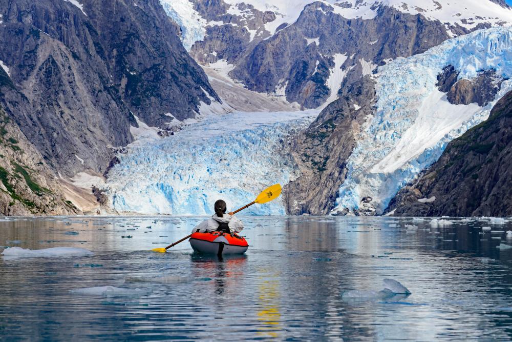 A kayaker floats through a canyon of ice