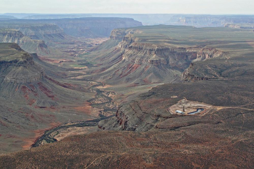 Aerial view of large canyon with small human-made development visible on near rim