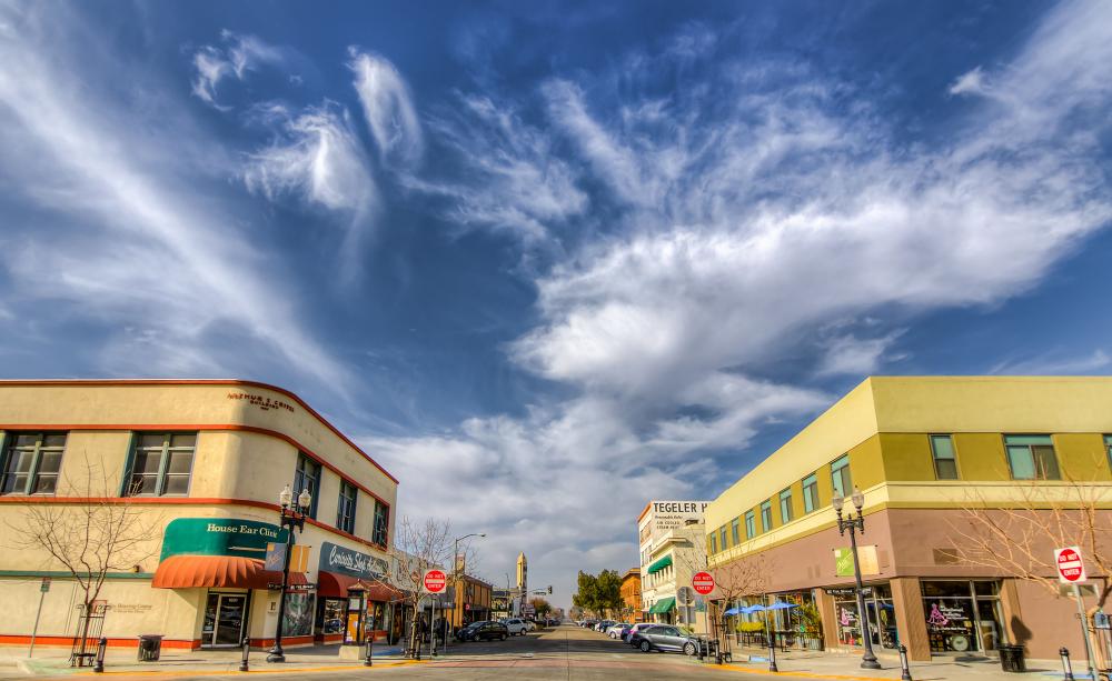 Dos edificios amarillos de dos pisos en el centro de Bakersfield con un cielo azul al fondo.