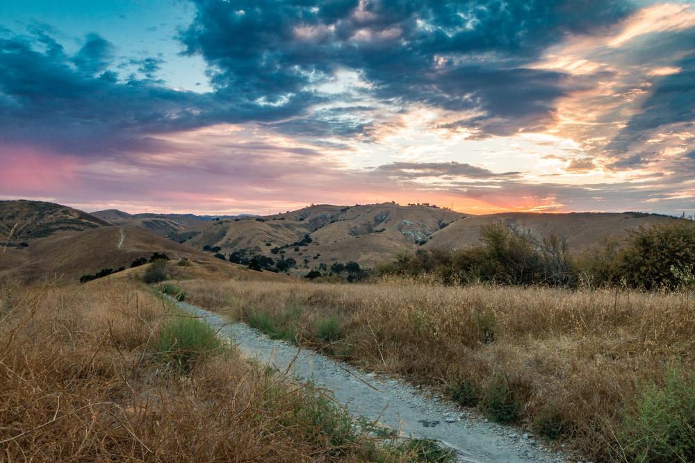 Sunrise over mountains and grassy field in Santa Monica Mountains National Recreation Area, California