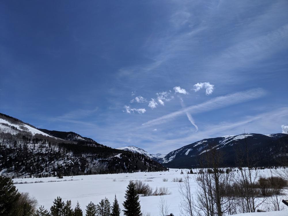 Snowy valley floor surrounded by snow-streaked mountains