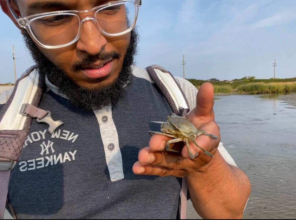 man holding a blue crab 