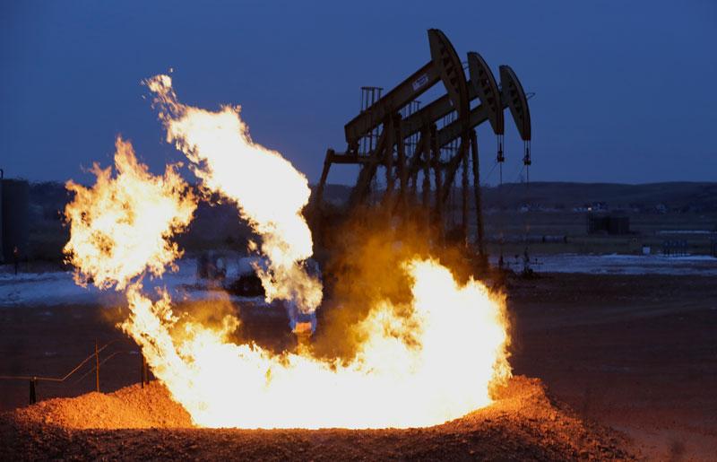 Fire with oil rigs in background