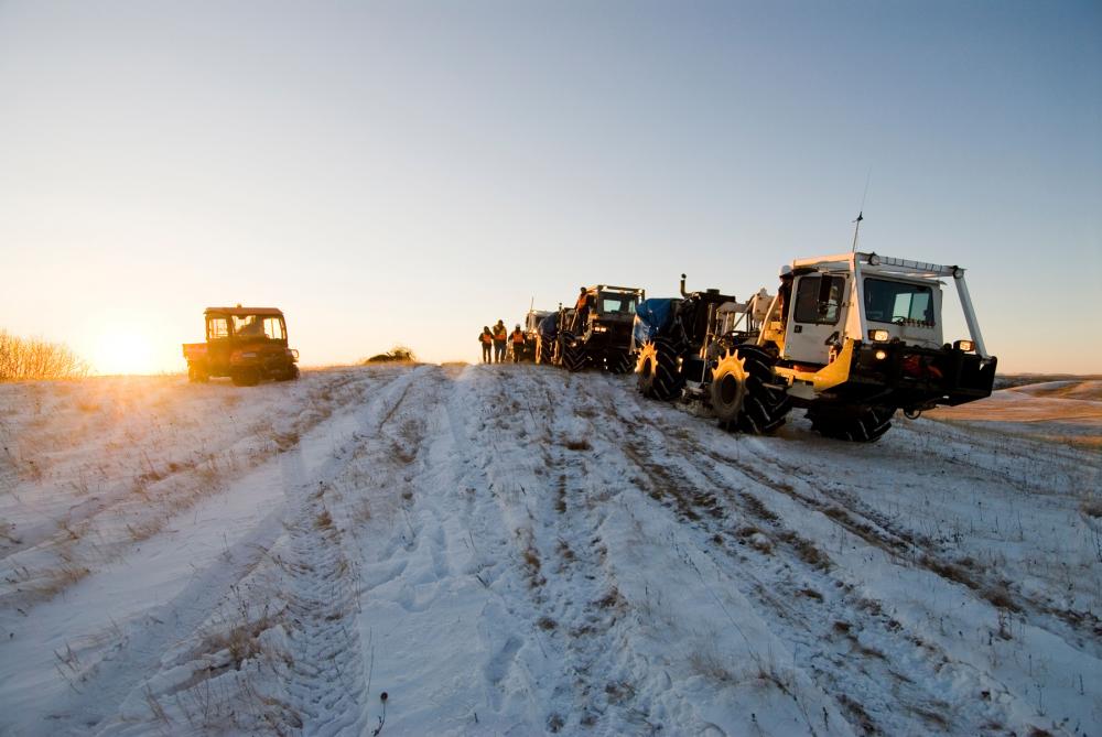 Heavy construction-type vehicles on a snowy field 