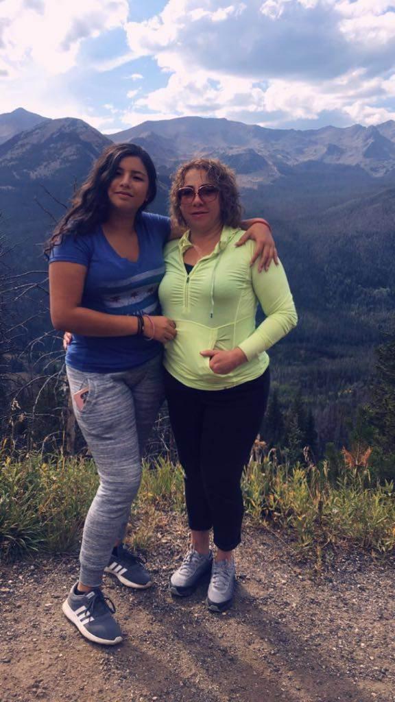 Two people standing in front of mountains