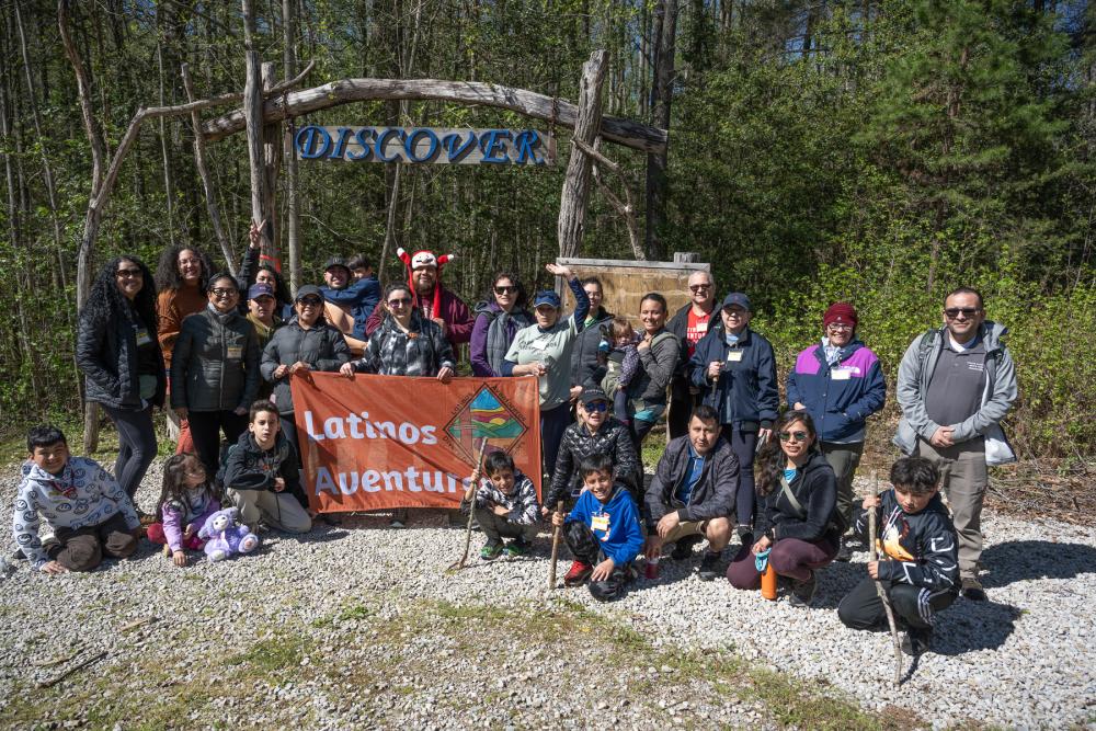people gathering with a banner that says "latino aventureros"