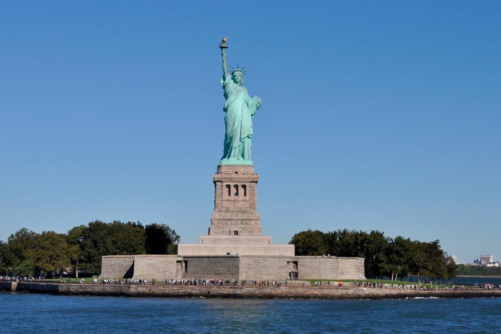 The Statue of Liberty on Ellis Island in New York City against a blue sky 