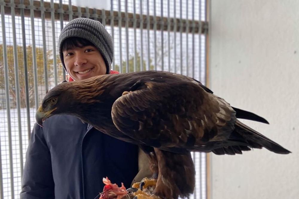 man holding a falcon on his arm