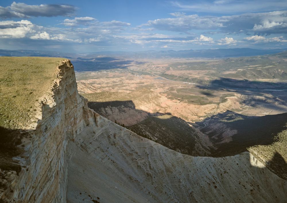 Aerial photo of Roan Plateau with a blue sky and clouds overhead