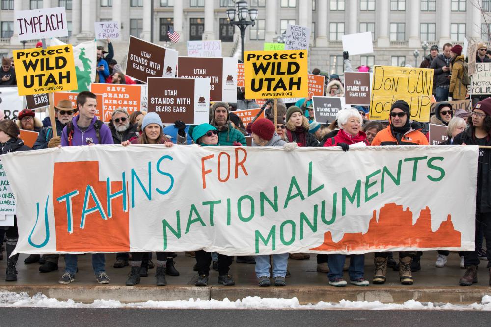 Group of people protesting with banner reading "Utahns for National Monuments"