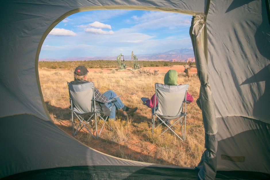 Two people overlooking wilderness plagued with oil rigs