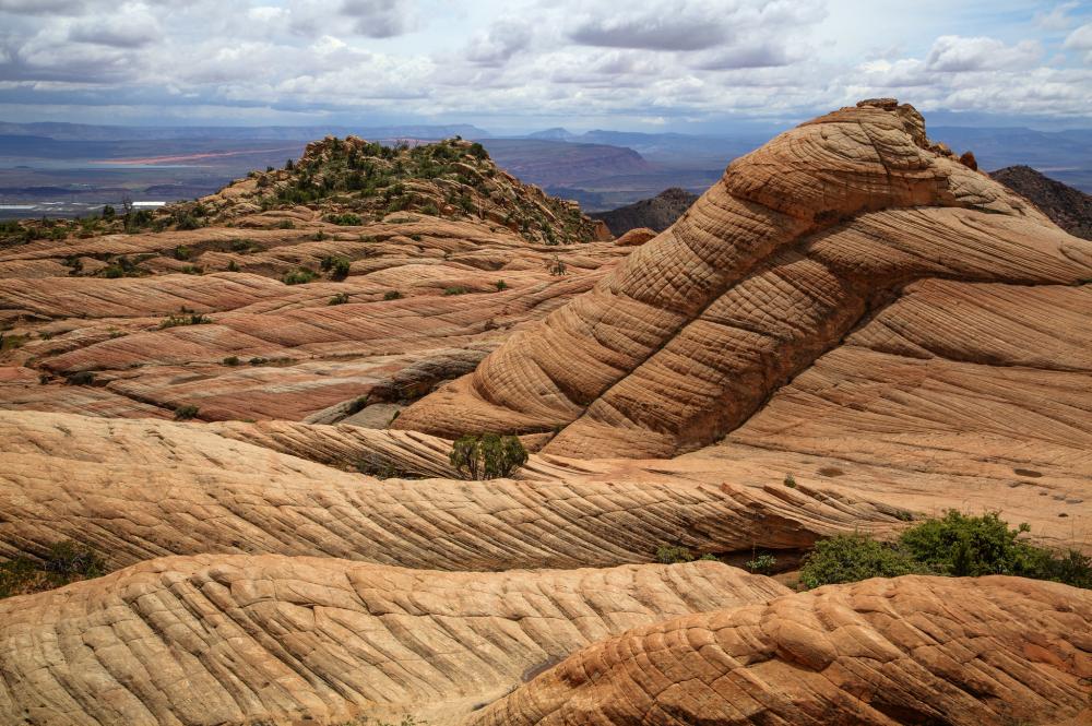 Undulating rocky formations in desert underneath cloudy skies