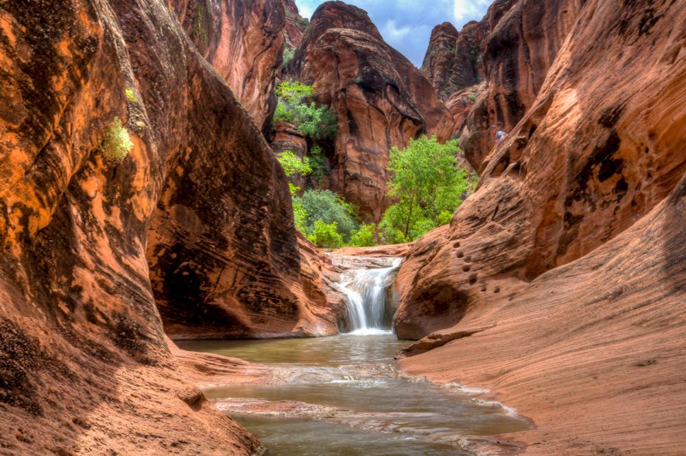 Waterfall at the center of a red-rock landscape in Red Cliffs National Conservation Area, Utah