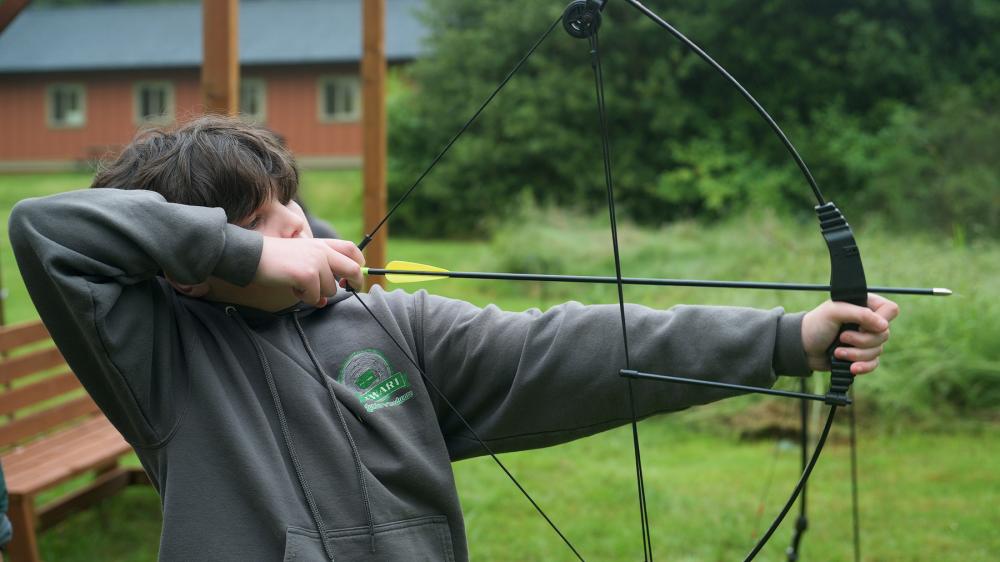 kid doing bow and arrow