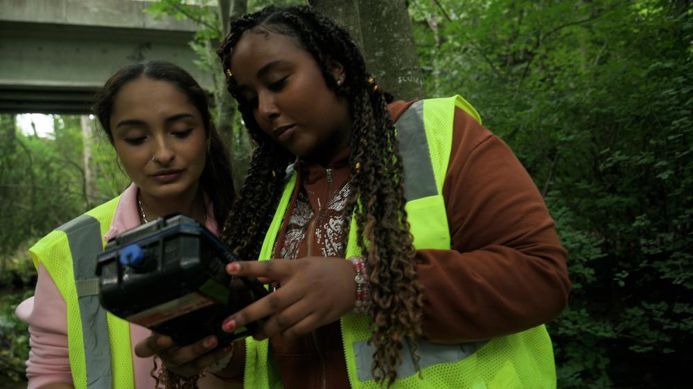 two teenagers checking water quality