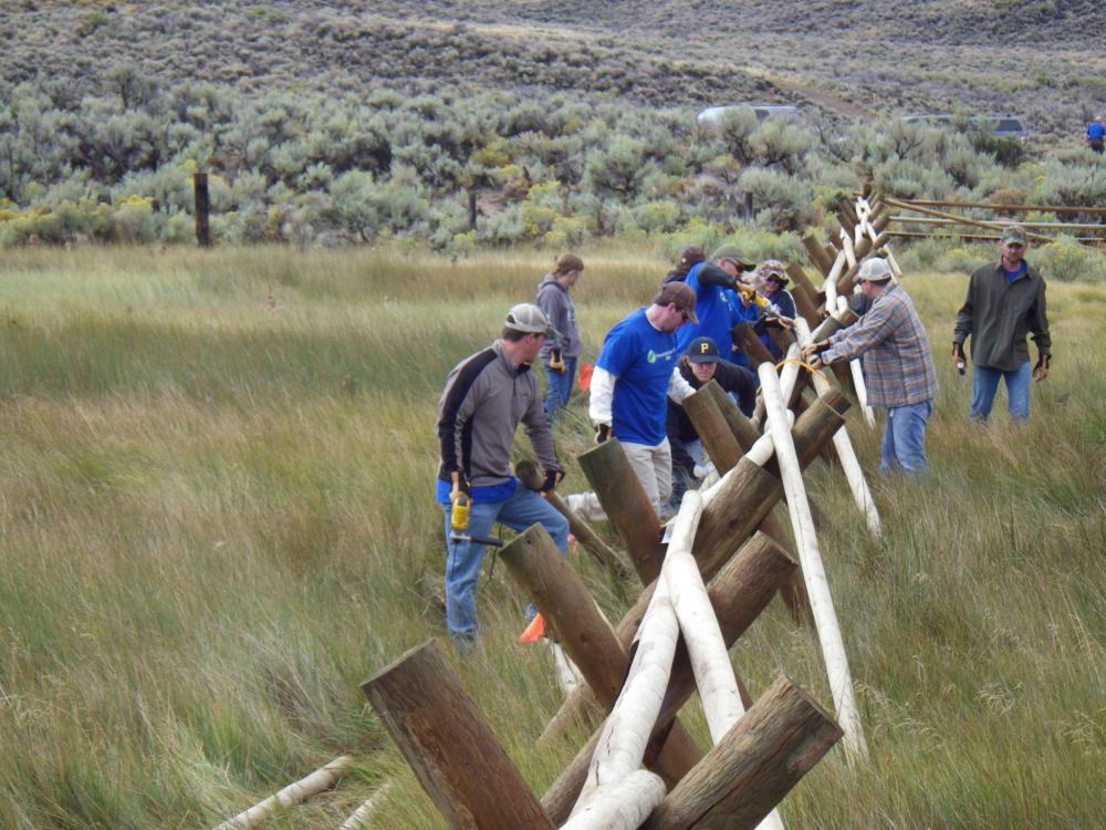 Volunteers repair fence amid windswept grassland in Greater Sand Dunes, Wyoming