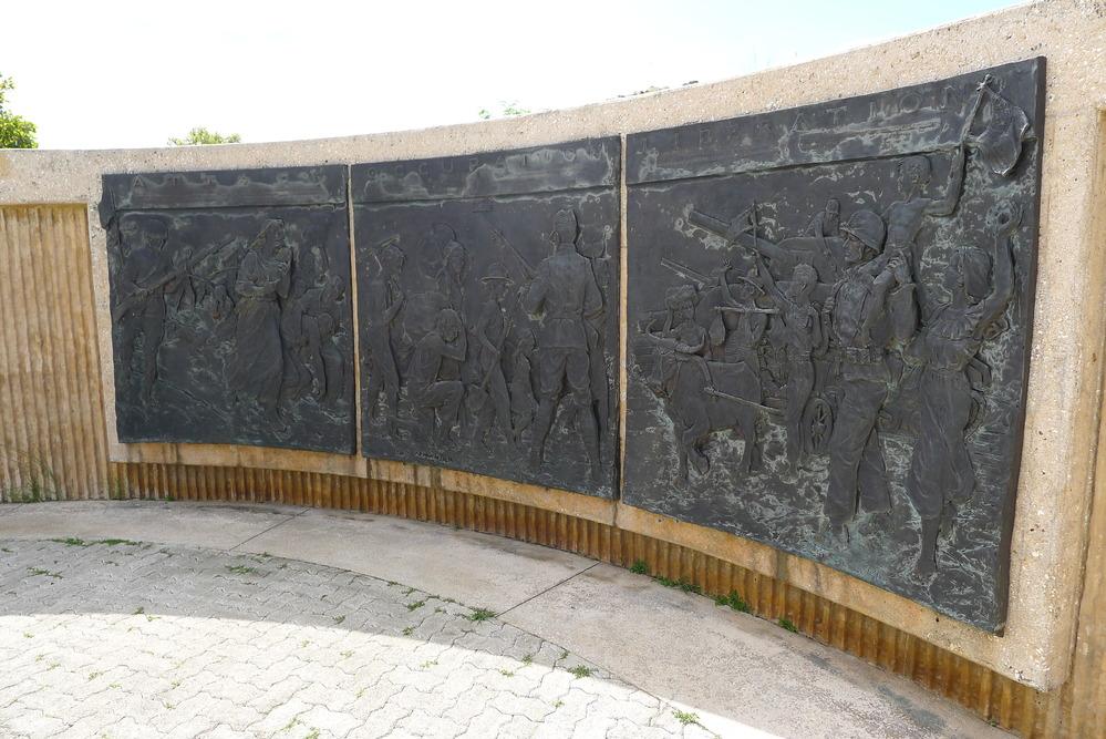 Memorial on wall depicting families and people running from an invasion. 