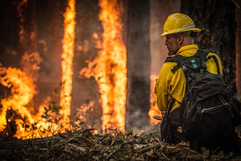 A firefighter in Oregon oversees a prescribed burn to help stop a larger wildfire. 